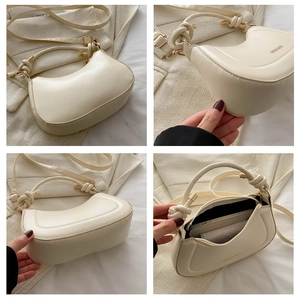 Detail view of cream crescent bag with knotted handle and interior storage space