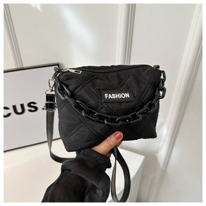 Dettaglio della borsa shopper nera trapuntata con catena spessa ed etichetta FASHION