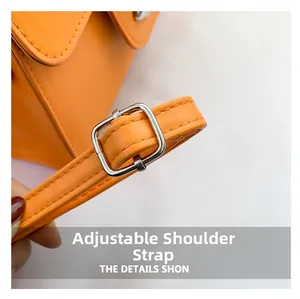 Detail of adjustable orange faux leather shoulder strap with polished silver buckle