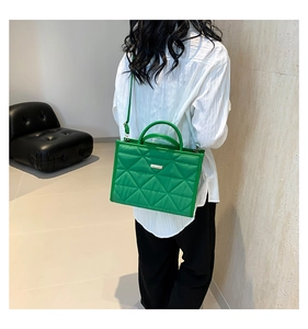 Detail of bright green quilted handbag with gold hardware and stylish triangular stitching