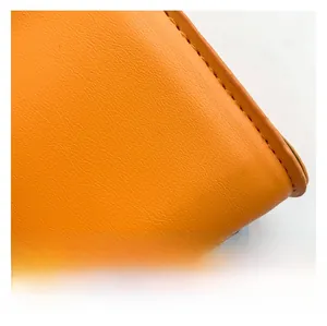 Detailed close-up of orange leather texture with premium lychee grain and neat stitching
