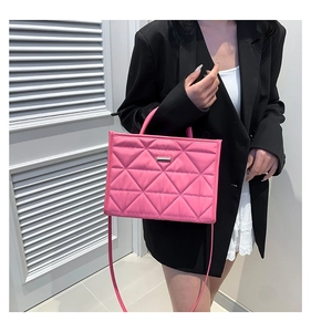 Detail of pink quilted handbag with silver metal bar decoration and crossbody strap