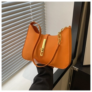 Detail view of orange retro shoulder bag with gold metal buckle and chain decoration