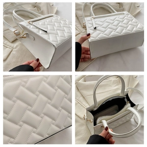 Detail view of white quilted handbag showing texture, inner lining and golden hardware
