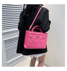 Close-up of pink quilted tote bag showing geometric stitching and gold hardware detail