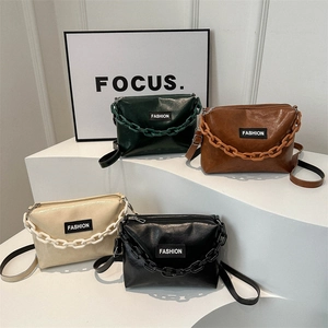 Square chain crossbody bags in dark green, brown, beige, and black on white stairs