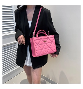 Detailed view of pink quilted handbag with triangular stitching and adjustable shoulder strap