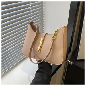 Detail of beige crescent underarm bag with gold chain strap and metal lock closure