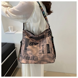 Détail du sac fourre-tout avec imprimé journal et bandoulière colorée à motifs de lettres