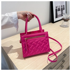 Detail of rose pink quilted handbag with gold zipper accent and adjustable shoulder strap