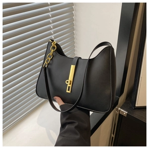 Close-up of black matte faux leather handbag with golden metal lock and chain strap