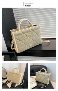 Detail of khaki quilted tote bag with geometric stitching and golden metal hardware