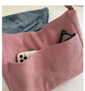 Detailed close-up of pink corduroy tote bag with front pocket showing internal storage space