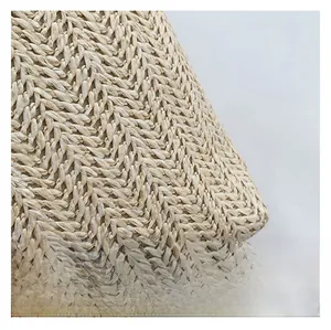 Macro shot of high-quality woven straw fabric with detailed herringbone texture in beige