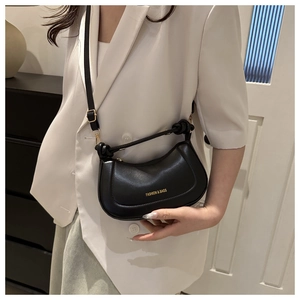 Detailed side view of black matte leather crescent bag with adjustable metal buckle strap