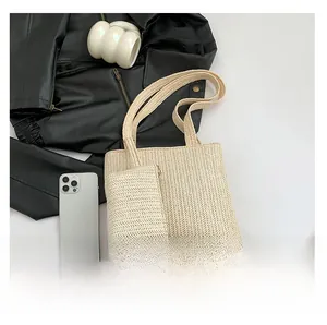 Detailed view of large beige woven straw tote bag with matching mini zipper pouch