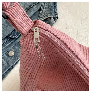 Detail of pink corduroy tote bag featuring smooth silver zipper and cute dog charm