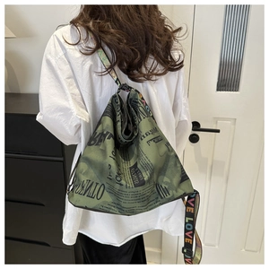 Détail du sac fourre-tout vert armée avec imprimé journal et bandoulière LOVE arc-en-ciel
