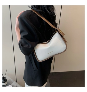 Detailansicht der Kontrastnähte und des goldenen Logos auf der Lederschultertasche
