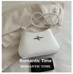 White faux leather shoulder bag with silver star detail and phone for size comparison