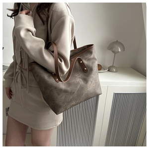 Detail of vintage brown tote bag with distressed texture and leather shoulder straps