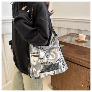 Gros plan du sac cabas imprimé journal avec bandoulière large aux logos colorés