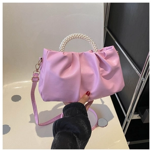 Detail of pink pleated cloud bag featuring elegant pearl handle and soft PU texture