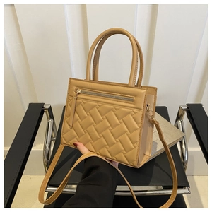 Detail of quilted rhombic texture and zipper on khaki faux leather handbag