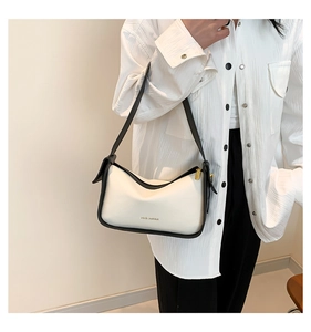 Detail der weißen PU-Schultertasche mit schwarzem Rand und Rich Rabbit-Aufdruck am Model