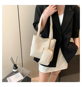 Detail of beige woven straw tote set with matching pouch and herringbone texture