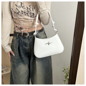 Close-up of white leather shoulder bag with silver star logo and knotted rope strap