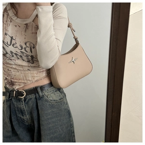 Chic beige leather shoulder bag with star buckle shown in a mirror selfie outfit pose