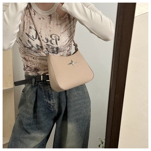 Close-up of beige leather shoulder bag with silver star stud detailing for daily wear