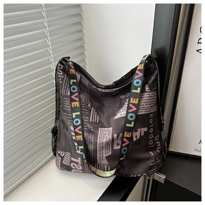 Détail du sac cabas en nylon avec imprimé journal et bandoulière LOVE colorée