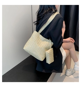 Detail of beige woven tote bag set showing herringbone texture and shoulder strap