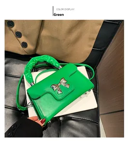 Detail of green candy color mini bag with silver bow hardware and ruched handle