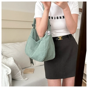 Mirror selfie showing the large mint green corduroy tote bag size and styling for women