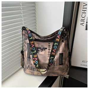 Détail d'un sac fourre-tout à imprimé journal avec une bandoulière arc-en-ciel LOVE