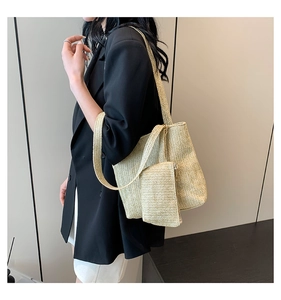 Detailed herringbone texture of a straw tote bag with a matching zipper pouch set