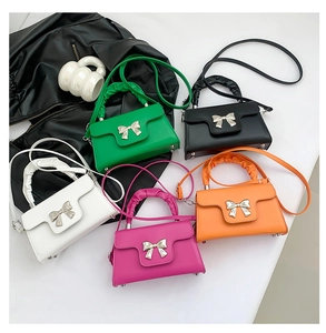 Detail of colorful crossbody bags with silver metal bow buckles and ruched handles