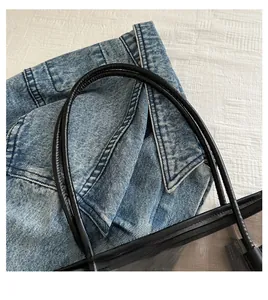 Close-up of black leather handles and durable stitching on a clear PVC tote bag