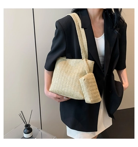 Detail of woven straw tote bag with a matching small pouch worn with a chic blazer