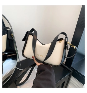 Detailaufnahme der Retro-Kontrast-Handtasche aus Leder mit goldenem Rich Rabbit Logo-Schriftzug