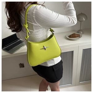 Detail of lime green leather underarm bag with silver star and knotted shoulder strap
