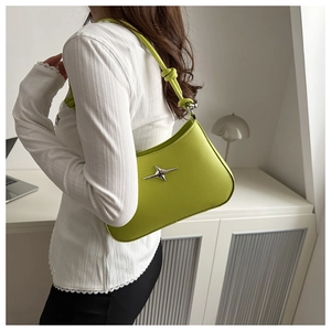 Detail of lime green crescent bag showing knotted shoulder strap and silver star charm