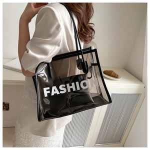 Detail of transparent black tote bag with FASHION text and inner pouch on model