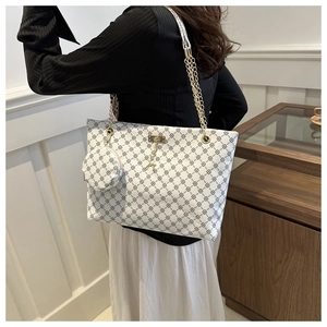 Detailed view of large tote bag with geometric print, gold chains, and mini coin purse