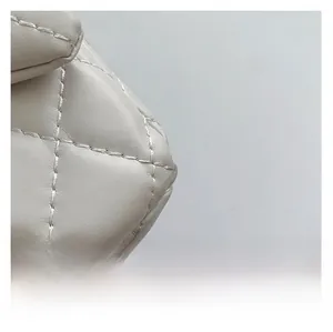 Close-up detail of quilted leather texture and premium stitching on a grey crossbody bag