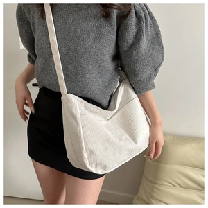 Detail of white corduroy tote bag featuring texture and external front pocket