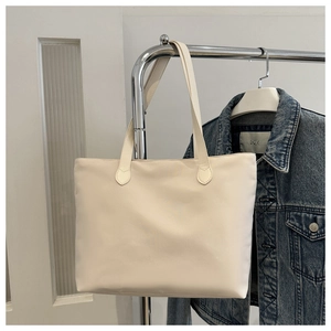 Detail of cream white nylon tote bag hanging on a silver hanger for casual daily use